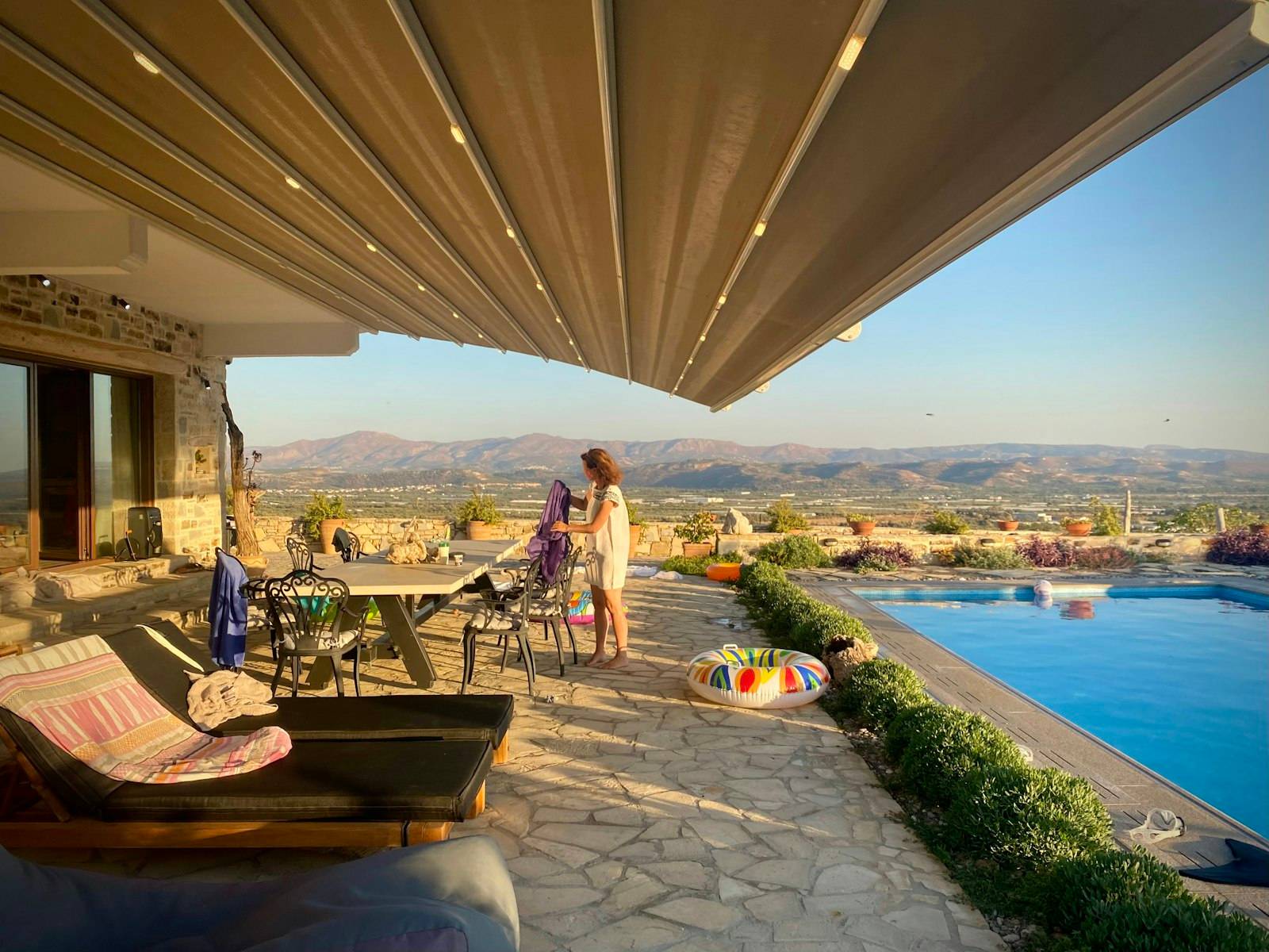 Grand store déployé au-dessus d'une terrasse de villa, au soleil couchant